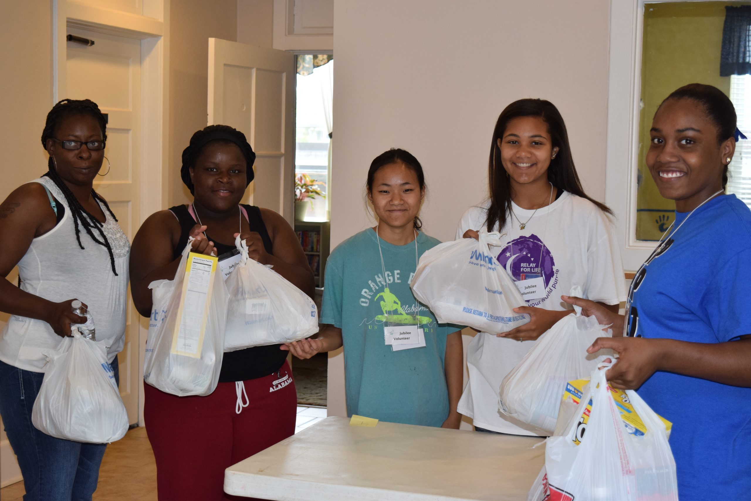 (l. to r.) Lakeshia Ratcliff, Tyeshianna Earl, Jenna Abel, Zion Roberts and Amya Moffite share “God’s Groceries” on distribution day at Jubilee Mennonite Church in Meridian, Mississippi. Amya and Jenna are two of the 2017 Class of Hope Scholars, who through Jubilee's Community of Hope serve 100 volunteer hours in exchange for mentoring and a college scholarship. (Photo provided by Laurie Oswald Robinson)