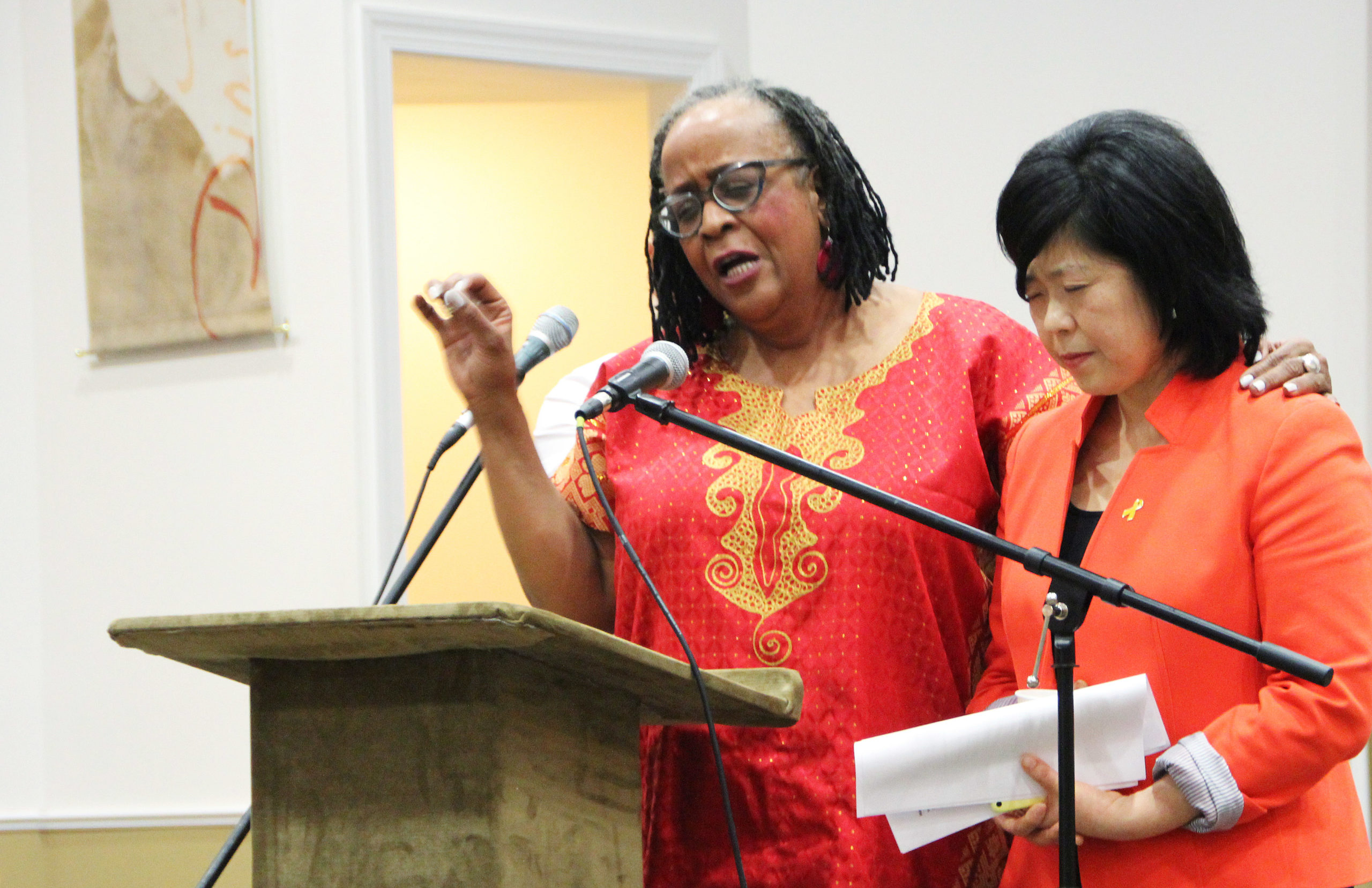 Michelle Armster, the interim executive director of Mennonite Central Committee Central States, prays over Sue Park-Hur, who preached the closing sermon on Sunday at Hope for the Future. (Photo by Andrew Bodden) 