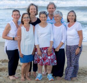 Seven adults posing on a beach