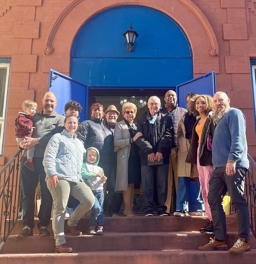 Group of 13 people on the doorstep of a church