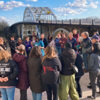 Sankofa Journey participants gather at the base of the Edmund Pettis Bridge in Selma, Alabama.